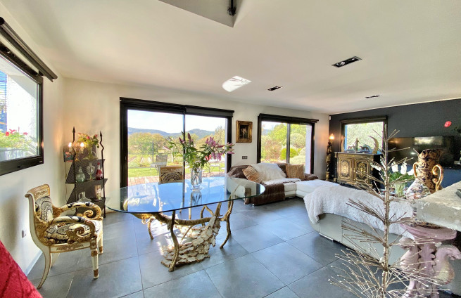 bright living room with bay windows and a garden/pool view
