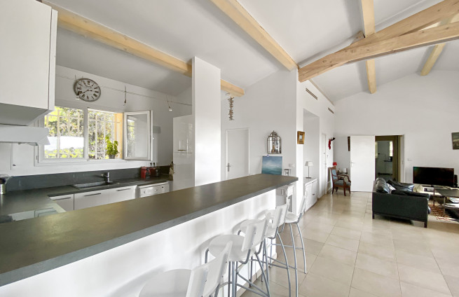 Open keuken die uitkomt op een terras met uitzicht op zee.