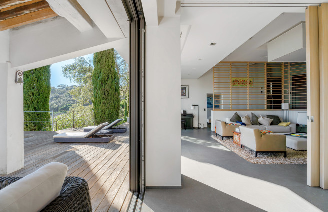 Woonkamer met open haard en toegang tot een panoramisch terras.